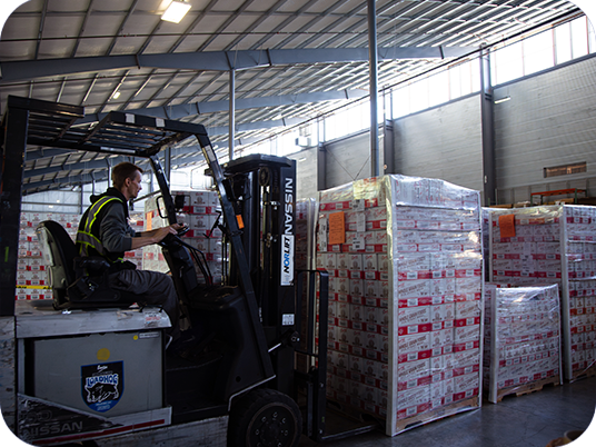 Man with a non apparent disability operating a fork lift in a warehouse